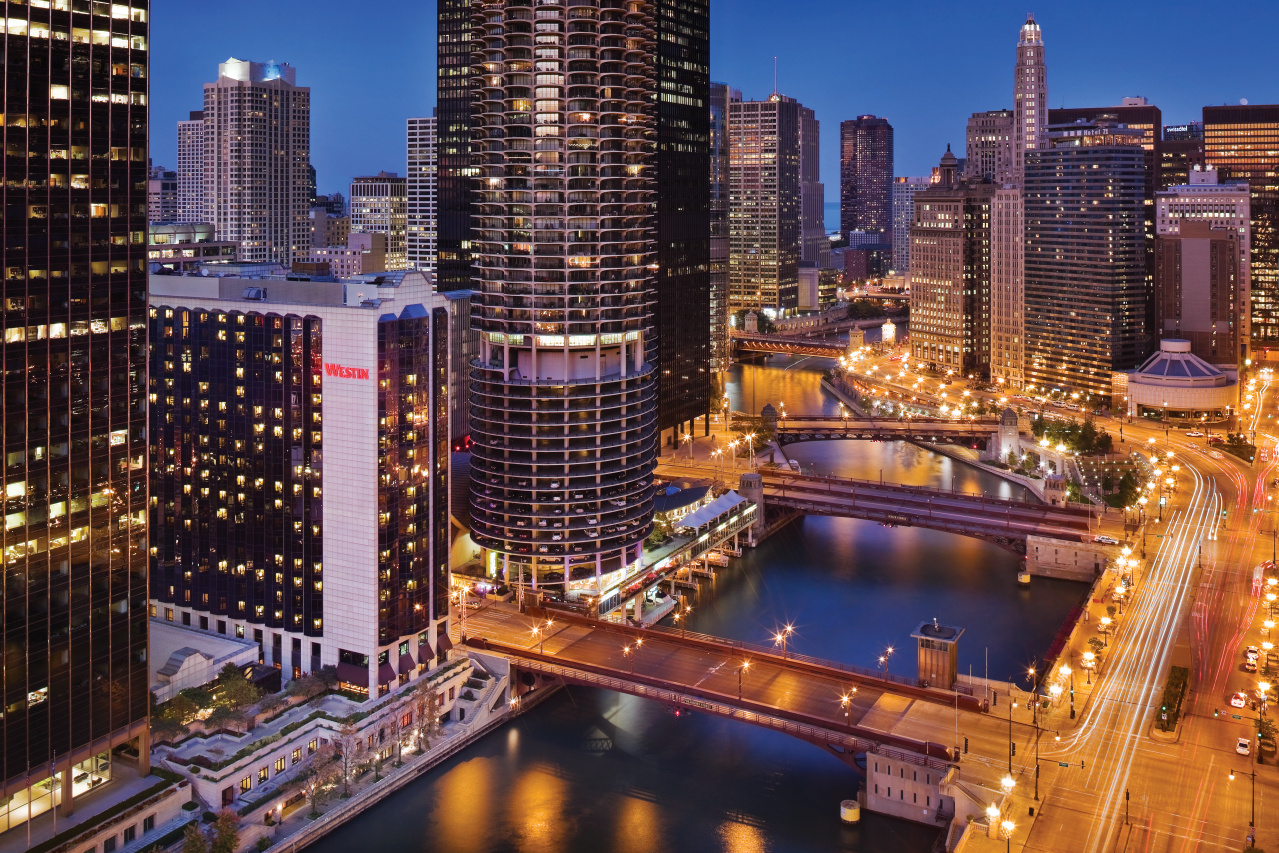Aerial of buildings, river, and bridges at dusk